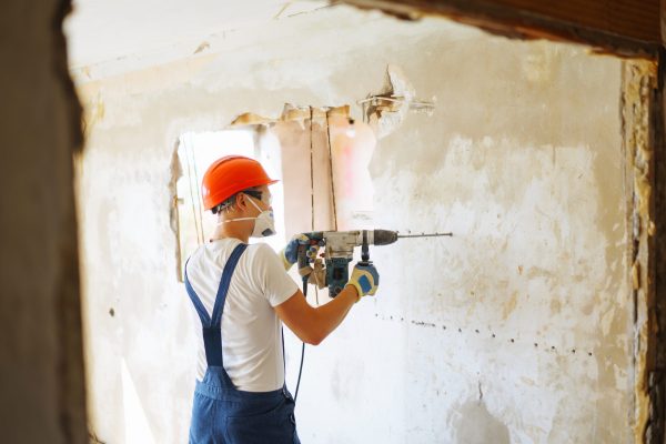 Repairer in boilersuit holding tools. Apartment repair and renovation concept. Building.